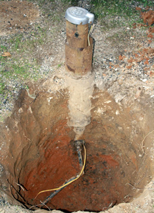 Agujero cavado que muestra la vista lateral de las tuberías de pozos de agua
