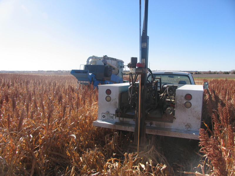 camión, tractor y equipo cosechando y recolectando muestras de suelo en el campo de sorgo